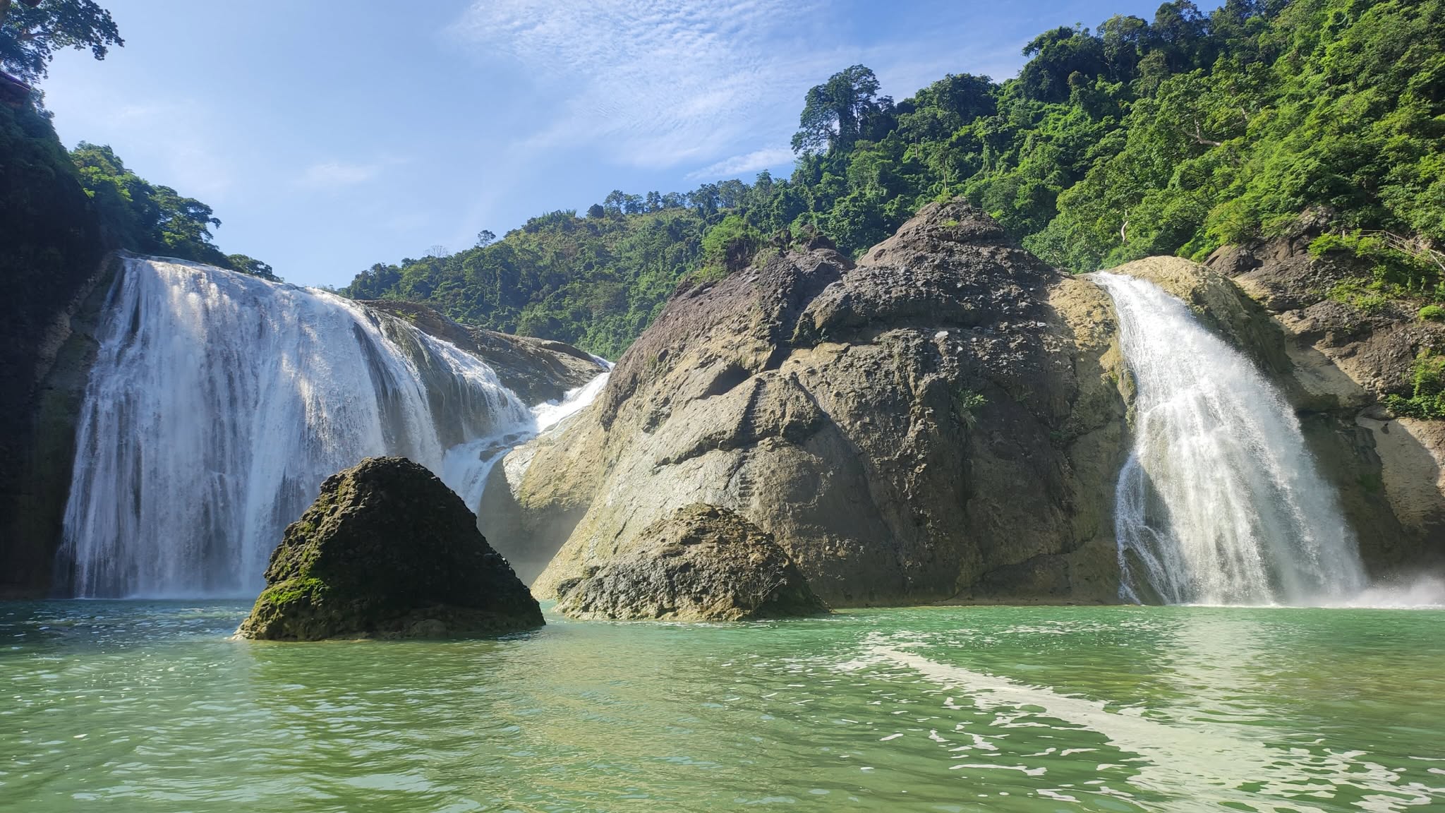 Pinsal Falls wide view from below showing the green pool and waterfall in Ilocos Sur
