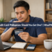 A young Filipino man thoughtfully holding a credit card at his home desk, weighing the decision of whether to get one.