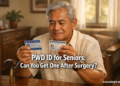 A Filipino senior man seated at a home table holds a PWD ID and a Senior Citizen ID, representing the question of whether seniors who had surgery can qualify for both IDs.