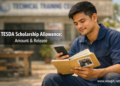 A Filipino TESDA scholar checks his phone for a LandBank allowance notification while keeping his own attendance notebook.